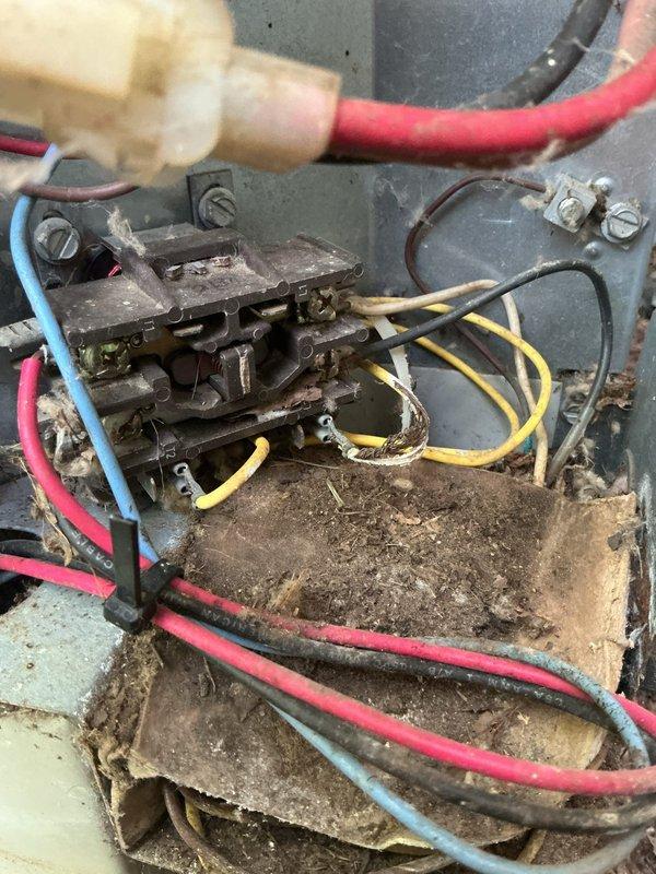 Completed comprehensive AC Super Tune-up on residential unit with significant maintenance needs. Upon arrival, found outdoor condensing unit area heavily obstructed by accumulated organic debris including wood chips, leaves, and mulch material covering ground-level components and pipe connections. Cleared debris from around gas lines, refrigerant connections, and electrical conduits to restore proper airflow and access for inspection.

Opened electrical junction box and discovered extensive dirt accumulation, corrosion, and deteriorated materials throughout contactor assembly and terminal connections. Cleaned all electrical terminals, wire connections, and contactor components. Inspected all wire insulation for damage and verified secure connections on red, blue, yellow, and black conductor terminations. Removed caked-on debris from junction box interior and metal backplate to prevent future electrical issues.

Performed standard tune-up protocol including system performance testing, a
