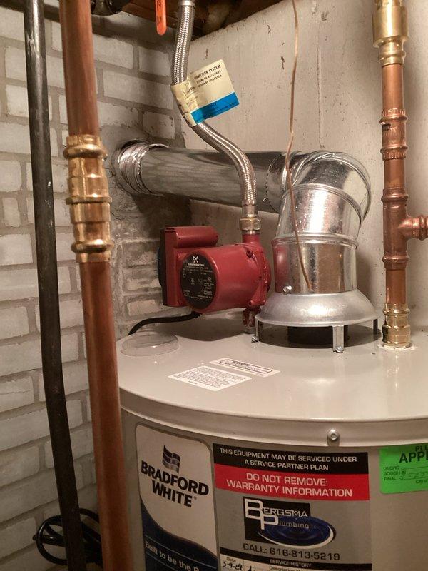 Responded to water quality and pressure concerns at residential property. Inspected Bradford White water heater installation with existing recirculation pump system and verified all connections, copper piping, and brass fittings were secure and functioning properly. Investigated reported basement noises and pressure drop issues, examining plumbing configuration and circulation system operation. Documented current water heater setup including recirculation pump mounted on outlet piping. Assessed kitchen plumbing fixtures including undermount double-basin sink and pull-down faucet for water delivery performance. Provided customer with quote options for reverse osmosis system installation and recommendations for improving hot water delivery time to remote areas of the home through additional recirculation solutions or point-of-use water heating alternatives.