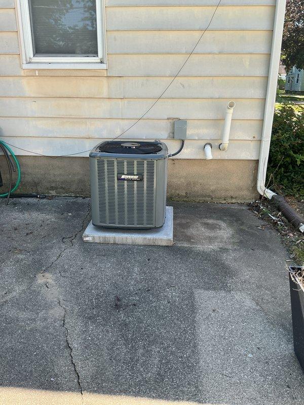 Completed full HVAC system replacement including outdoor condensing unit and indoor air handler. Installed new gray residential AC condenser on existing concrete pad with proper refrigerant line sets, electrical disconnect, and PVC condensate drainage. Mounted new air handler unit in utility room with copper and PVC plumbing connections integrated with existing water heater infrastructure. All equipment secured per manufacturer specifications, electrical connections verified, refrigerant lines pressure tested and charged to proper levels, and condensate drainage system confirmed operational.