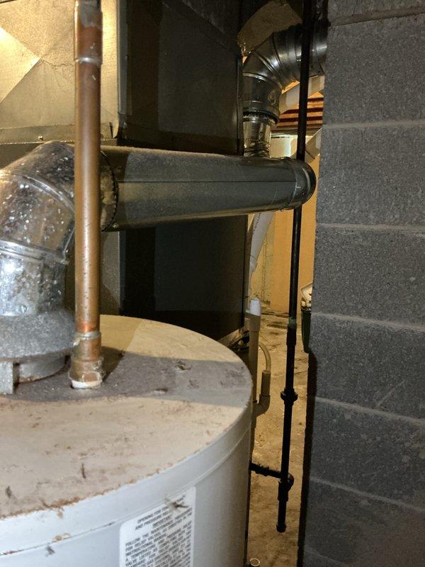 Completed rental inspection of water heater in basement mechanical room as requested. Documented water heater condition, brand identification, and age determination through photographic evidence. Unit is a standard residential gas-fired water heater with copper supply piping and proper venting, located adjacent to HVAC equipment in concrete block foundation area.