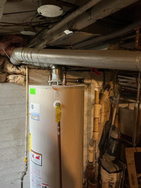 Conducted estimate for water heater replacement at client's request. Assessed existing GE water heater installation in basement utility area, documenting current configuration including copper and PVC supply lines, metallic exhaust venting, and connections to home plumbing system. Photographed unit specifications, manufacturer labels, and surrounding plumbing infrastructure to provide accurate replacement quote for client-selected water heater model.