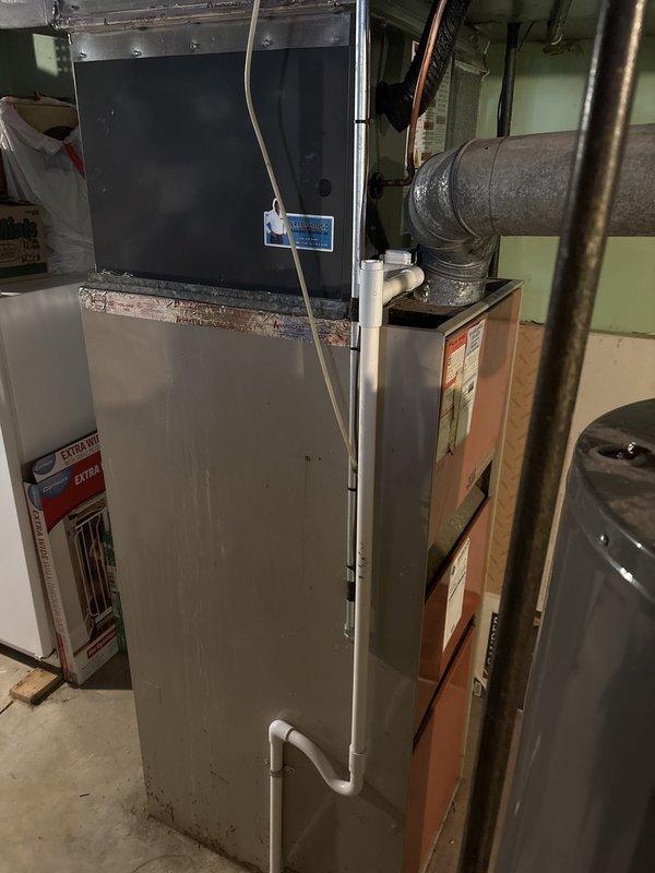 Completed full HVAC system installation in basement mechanical room, including new furnace and air conditioning components. Installed beige residential furnace unit with integrated air handler, established all necessary PVC condensate drainage lines, and connected metallic supply ductwork. Mounted digital control system, completed all copper refrigerant line connections, and verified proper flexible duct integration to existing distribution system. All equipment positioned for optimal serviceability, electrical connections secured, and system tested for proper operation.