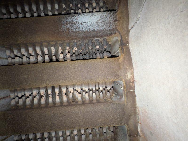 Responded to service call for non-operational boiler system approximately 40 years old. Conducted thorough inspection of heating unit and associated components. Visual examination revealed significant corrosion and rust on heat exchanger frame and casing, indicating extended service life and moisture exposure. Heat exchanger fins showed surface oxidation but remained structurally intact. Evaluated ductwork connections and basement installation conditions. Documented equipment condition through photography and provided customer with assessment findings and repair versus replacement options given the age and deteriorated state of the system.