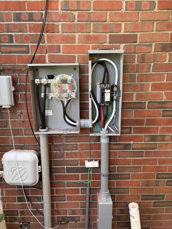 Completed exterior electrical service replacement and meter upgrade on residential brick structure. Coordinated utility disconnect and reconnect with power company, obtained electrical permit PE26000676, and installed new dual meter box assembly with gray metal enclosures mounted side-by-side on exterior wall. Ran new service entrance conductors through gray PVC conduit system secured to brick wall, terminated connections at meter bases and interior panel. Installed white PVC conduit run with grounding conductor (green wire) from service equipment to grounding electrode system at grade level. All work completed per NEC standards and passed electrical inspection.
