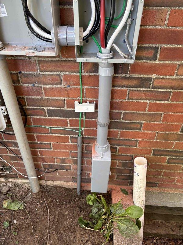 Completed exterior electrical service replacement and meter upgrade on residential brick structure. Coordinated utility disconnect and reconnect with power company, obtained electrical permit PE26000676, and installed new dual meter box assembly with gray metal enclosures mounted side-by-side on exterior wall. Ran new service entrance conductors through gray PVC conduit system secured to brick wall, terminated connections at meter bases and interior panel. Installed white PVC conduit run with grounding conductor (green wire) from service equipment to grounding electrode system at grade level. All work completed per NEC standards and passed electrical inspection.