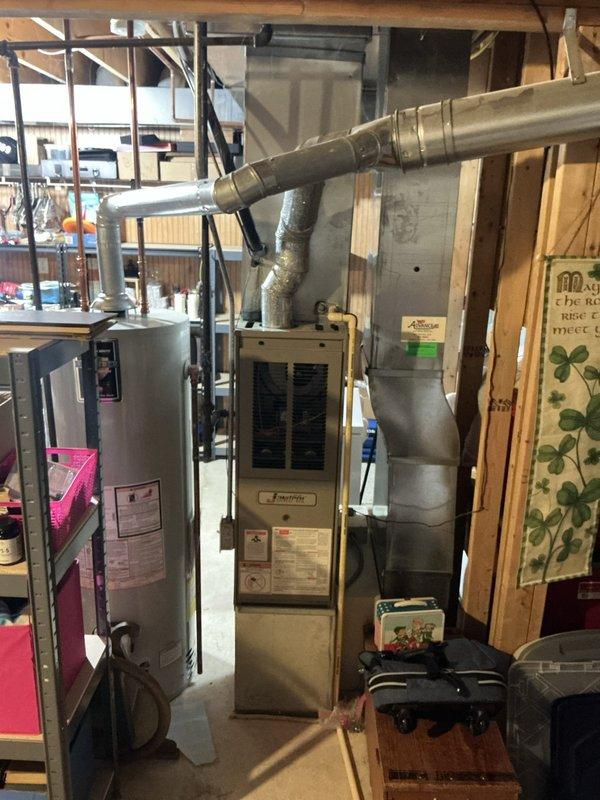 Completed comprehensive tune-up service on 25-year-old residential air conditioning system located in basement utility area. Performed standard maintenance procedures including inspection of furnace unit, ductwork connections, and HVAC components to ensure proper system operation and efficiency.