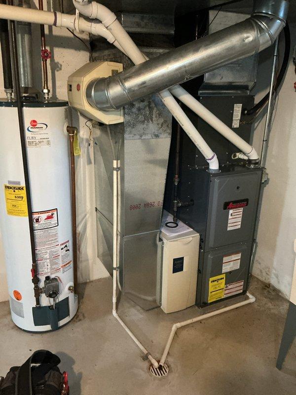 Responded to water leak complaint at furnace system in side-by-side condo. Upon inspection, identified active leak at furnace valves while system maintained heating capability. Documented equipment condition and leak location with photographs showing HVAC system, water heater, humidifier unit, and associated piping in mechanical room. No immediate safety concerns observed and heating function remained operational at time of service.