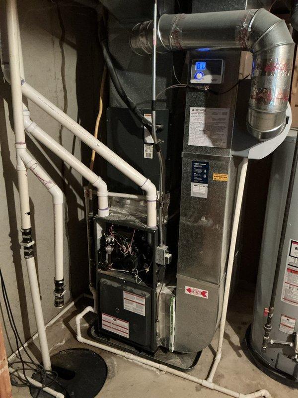 Completed furnace and air conditioning estimate for a residential system with a 22-year-old outdoor condensing unit. Performed comprehensive AC tune-up and system evaluation, documenting equipment condition through photographs of both the exterior condenser unit with protective cage and the interior basement mechanical room housing the furnace and air handler. Assessment focused on repair costs versus equipment age to provide replacement recommendations, with Friends and Family discount applied to the tune-up service.