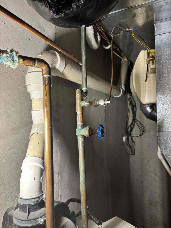 Provided estimate for replacement of 21-year-old power vented natural gas water heater (50-gallon capacity) in single family residence. Documented existing plumbing configuration including copper supply lines with visible corrosion and oxidation on fittings, existing venting system with PVC components, and current mechanical room layout to determine replacement specifications and installation requirements.