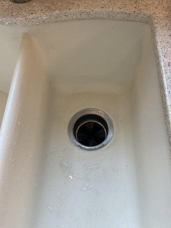 Responded to leaking garbage disposal complaint. Upon inspection, found 1/2 horsepower InSinkErator disposal unit installed under kitchen sink with active leak. Diagnosed leak source, performed necessary repairs to disposal unit and associated drain connections. Verified all mounting hardware, drain flange seal, and discharge connections were properly secured. Tested unit operation and confirmed leak was resolved with no further water discharge observed.