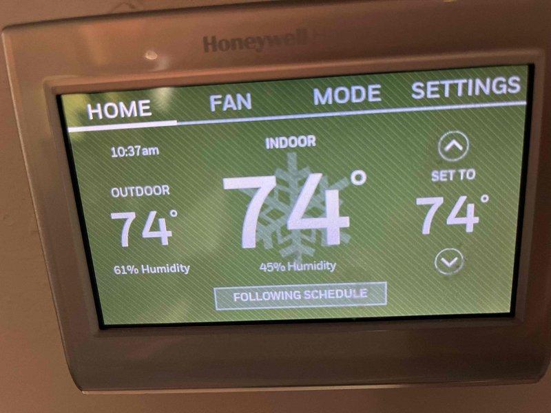 Completed annual AC tune-up on 7-year-old system for Consumers Energy customer. Discussed and provided information about Consumers Energy's Smart Thermostat Program, which offers incentives for enrollment and allows minor temperature adjustments during peak demand periods. Verified Honeywell smart thermostat operation, confirming proper temperature control, humidity readings, and scheduling functionality with all settings displaying correctly at 74°F indoor temperature.