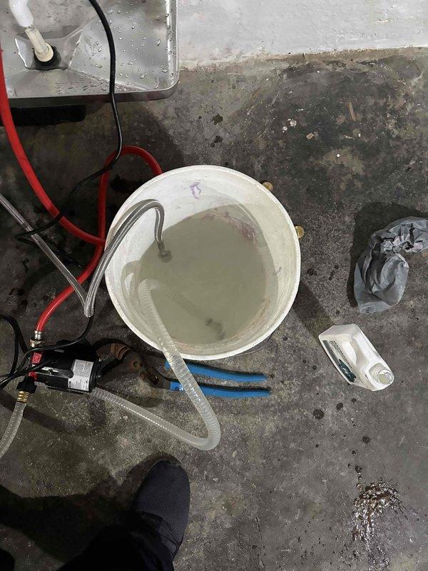 Responded to no-heat call on 2-year-old Navien tankless water heater. Upon arrival, unit was non-operational. Performed descaling flush procedure using cleaning solution and pump setup to remove mineral buildup from heat exchanger. Flushed both hot and cold side isolation valves with cleaning solution circulated through system. Verified proper operation of pre-filtration system. Unit restored to full functionality with adequate hot water production and normal operational parameters confirmed on digital display.