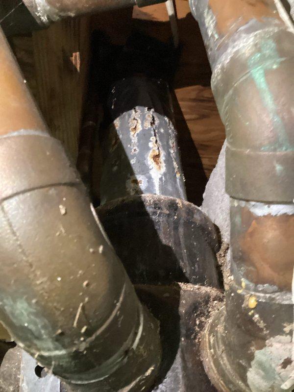 Conducted routine plumbing inspection in 1957-built home to investigate multiple leak sources in bathroom area affecting basement below. Inspected attic and crawl space plumbing infrastructure, identifying significant corrosion on HVAC ductwork with visible rust staining and water damage patterns. Examined copper supply lines, drain connections, and pipe joints throughout affected areas. One leak confirmed as long-standing issue with several months of active water intrusion, while second leak resulted from recent homeowner-attempted plumbing repair. Documented extensive rust deterioration on metal duct boot connections and elbow joints, along with water residue streaking on vertical ductwork surfaces. Photographed corroded components, aging pipe insulation, and compromised connections for repair recommendations. Verified customer contact information for follow-up scheduling.