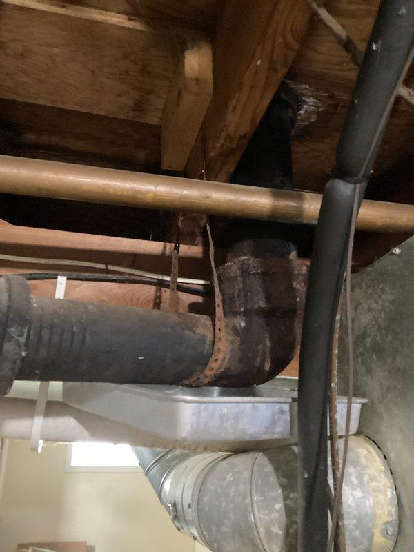 Conducted routine plumbing inspection in 1957-built home to investigate multiple leak sources in bathroom area affecting basement below. Inspected attic and crawl space plumbing infrastructure, identifying significant corrosion on HVAC ductwork with visible rust staining and water damage patterns. Examined copper supply lines, drain connections, and pipe joints throughout affected areas. One leak confirmed as long-standing issue with several months of active water intrusion, while second leak resulted from recent homeowner-attempted plumbing repair. Documented extensive rust deterioration on metal duct boot connections and elbow joints, along with water residue streaking on vertical ductwork surfaces. Photographed corroded components, aging pipe insulation, and compromised connections for repair recommendations. Verified customer contact information for follow-up scheduling.