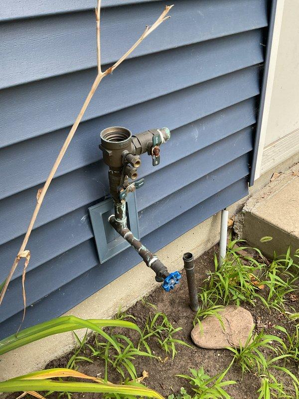Replaced defective exterior spigot on 60-year-old residence that had been malfunctioning for two weeks. Installed new brass faucet assembly with shutoff valve on blue-gray vinyl siding, ensuring proper connection to existing copper supply lines and secure mounting to exterior wall. Verified system operation and documented completed installation with photographs.