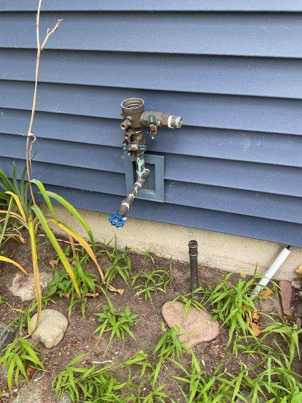 Replaced defective exterior spigot on 60-year-old residence that had been malfunctioning for two weeks. Installed new brass faucet assembly with shutoff valve on blue-gray vinyl siding, ensuring proper connection to existing copper supply lines and secure mounting to exterior wall. Verified system operation and documented completed installation with photographs.