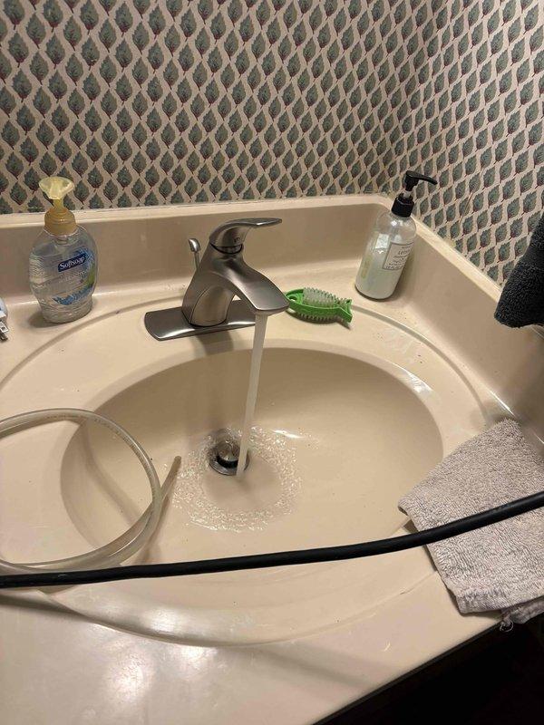 Responded to callback for leaking faucet that had been recently replaced. Upon inspection, verified active leak at bathroom sink faucet with water running into basin. Troubleshot the installation to identify source of leak. Adjusted and properly secured faucet connections, ensuring all supply line fittings were tight and sealed correctly. Verified P-trap assembly and drain connections were functioning properly with no additional leaks present. Tested faucet operation and confirmed leak was resolved with no further water discharge.