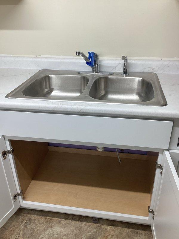 Responded to a basement kitchen plumbing service call to connect a faucet to existing water supply lines. Upon arrival, found an installed stainless steel double-basin sink with chrome faucet and sprayer attachment, but supply lines were not connected beneath the cabinet. Successfully connected the hot and cold water supply lines to the faucet assembly, tested for leaks, and verified proper water flow and drainage. Additionally inspected the gas oven as requested due to reported gas odor during operation, assessed the appliance for potential gas leaks or ventilation issues to ensure safe operation.
