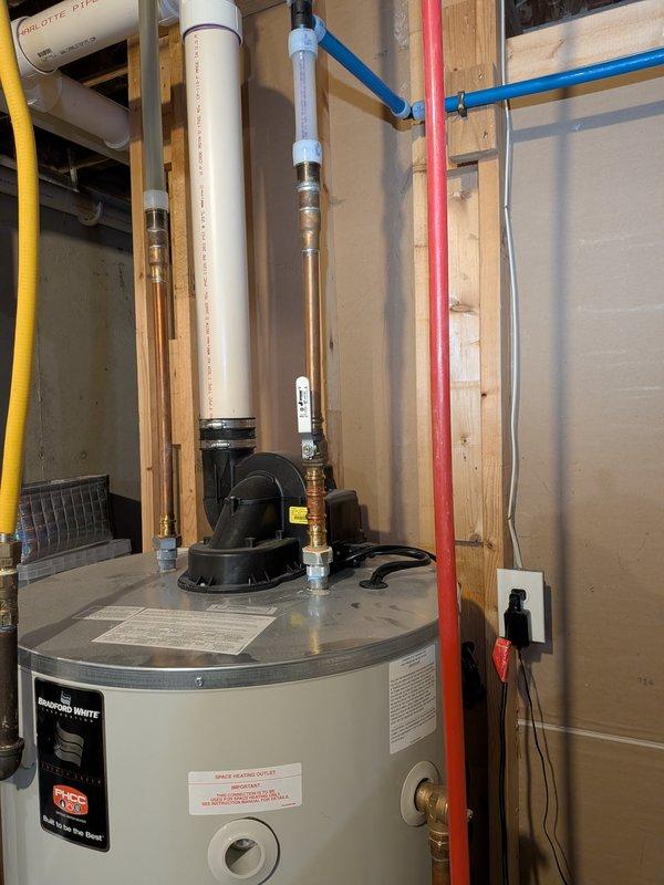 Responded to service call for leaking 10-year-old water heater. Upon inspection, identified active leak requiring immediate attention. Documented existing water heater installation including all plumbing connections, PEX piping, copper lines, and associated mechanical equipment in utility area for service records.