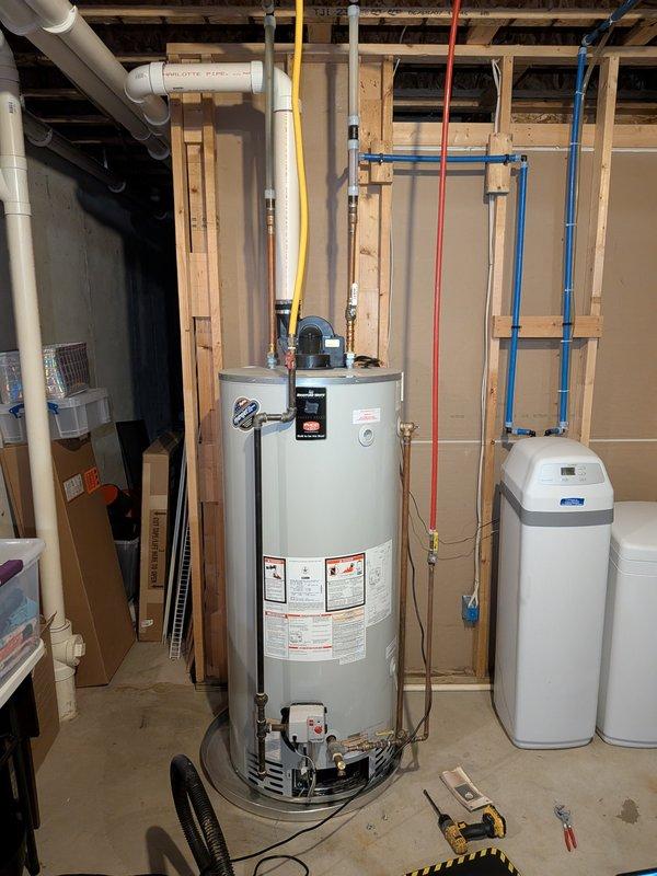 Responded to service call for leaking 10-year-old water heater. Upon inspection, identified active leak requiring immediate attention. Documented existing water heater installation including all plumbing connections, PEX piping, copper lines, and associated mechanical equipment in utility area for service records.