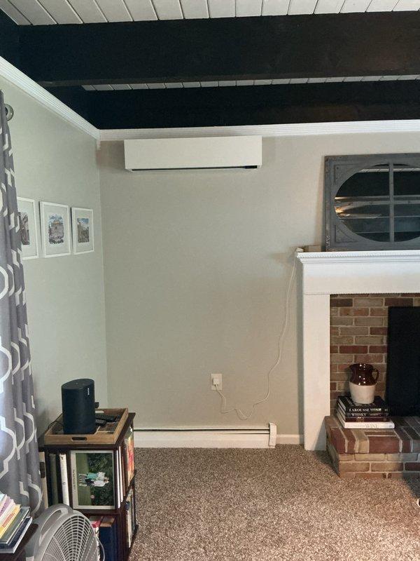 Completed installation of ductless mini-split system at residential property. Installed outdoor condensing unit on concrete pad against house foundation with proper refrigerant line connections and electrical supply. Mounted indoor wall-mounted air handler unit in living space near ceiling with line set routing through wall penetration. System tested and verified operational for both heating and cooling functions.