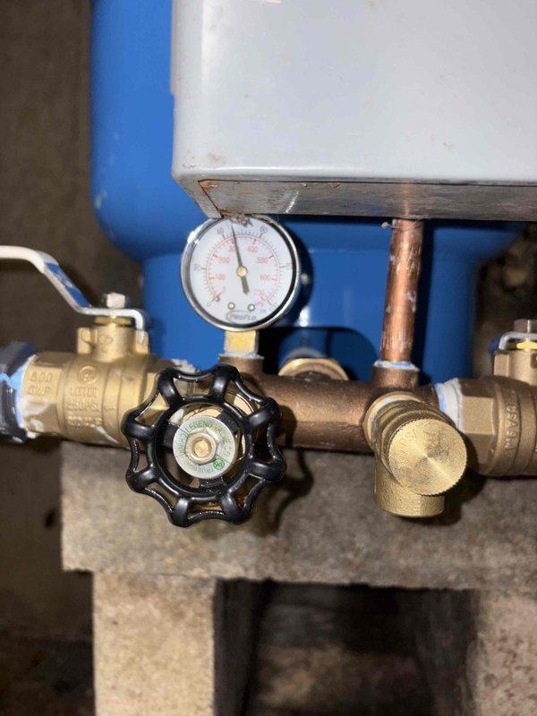 Completed comprehensive plumbing system repair on water heater installation with focus on pressure regulation and valve assembly replacement. Addressed deteriorated flexible connector hoses and corroded copper piping connections, installed new brass ball valves and pressure gauge assembly to restore proper system monitoring and flow control. Remediated moisture damage area and ensured all connections were properly sealed to prevent future water intrusion and corrosion issues.