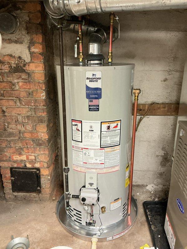 Successfully installed a 40-gallon Bradford White natural gas short water heater in basement utility area. Completed all plumbing connections using copper supply lines with brass fittings and shut-off valves, installed proper venting with galvanized ductwork, and secured unit on appropriate base. All manufacturer specifications verified, safety labels intact, and system tested for proper operation.