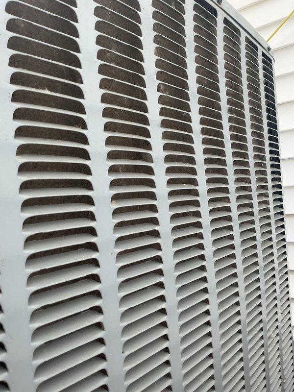 Responded to no cooling complaint on 10-year-old Daikin system affecting entire home. Confirmed unit was running but not producing cold air. Performed diagnostic inspection of outdoor condensing unit, documenting equipment condition and exterior components. Photos captured show outdoor unit with dirty/clogged condenser coil louvers containing significant dust and debris accumulation, restricting proper airflow through the heat exchanger. This contamination prevents adequate heat rejection and reduces system cooling capacity. Verified best contact number for follow-up communication regarding necessary repairs or maintenance to restore proper cooling operation.