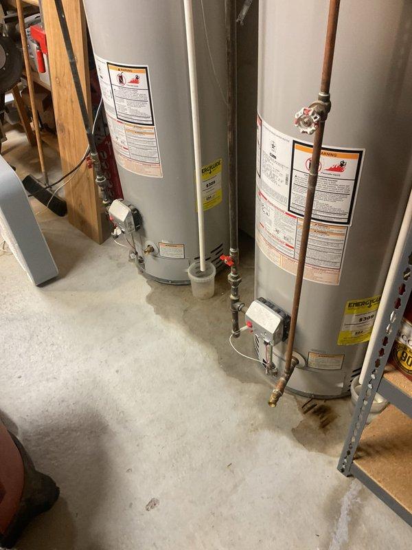 Responded to emergency call for 13-year-old Bradford White water heater experiencing steady water leak that extinguished pilot light and caused automatic system shutdown. Upon arrival, confirmed gas supply had been safely shut off by homeowner. Inspected unit and documented existing conditions with photographs showing dual water heater installation in basement utility area. Identified source of water intrusion causing safety shutdown of heating system. Unit displayed normal wear consistent with age and operational history.