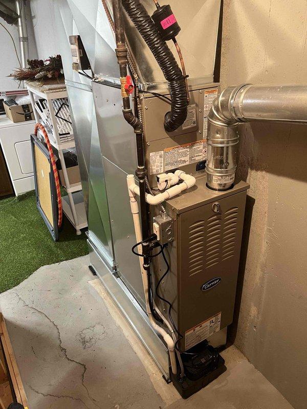 Completed full installation of residential furnace and air conditioning system in basement mechanical room. New furnace unit installed with proper venting, ductwork connections, and condensate drainage via PVC piping. All electrical connections, refrigerant lines, and flexible ductwork secured and tested for proper operation.