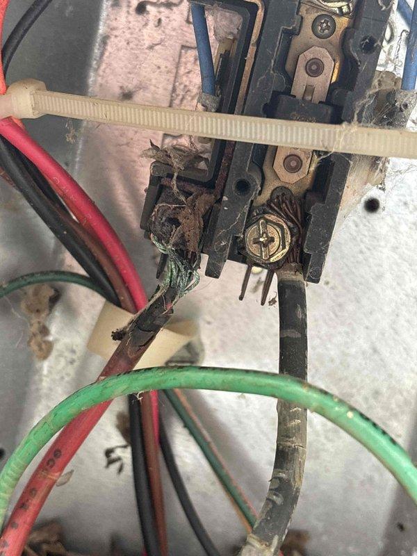 # Cooling System Electrical Failure - North End Unit

Responded to no-cooling complaint on 15-year-old air conditioning unit affecting north end of residence. Upon inspection, discovered extensive electrical terminal corrosion and contamination within outdoor condensing unit. Found severe rust and oxidation on primary electrical connections, compromising circuit integrity. Interior of electrical control panel heavily contaminated with organic debris, nesting material, and plant matter that had infiltrated the enclosure. 

Identified corroded wire terminals and connections at junction box as primary failure point preventing compressor operation. Capacitor and associated wiring also affected by debris accumulation and moisture intrusion. Cleaned electrical enclosure, removed all organic contamination, and replaced deteriorated terminals and corroded connections. Restored proper electrical continuity to control circuit. Verified capacitor function and all wire connections. Sealed enclosur