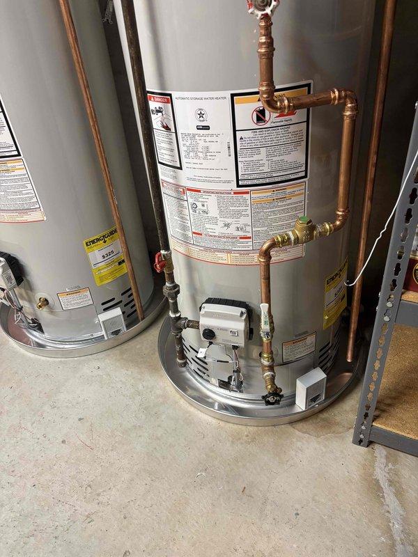 Completed twin water heater installation in basement utility room, installing two 50-gallon natural draft natural gas water heaters positioned side by side. Connected copper supply and discharge piping with brass fittings and valves to both units, installed proper venting through metal ductwork to ensure safe exhaust of combustion gases, and verified all gas connections for leak-free operation. Both water heaters are covered under 6-year parts and 1-year labor warranty, with installation completed per manufacturer specifications and local code requirements.