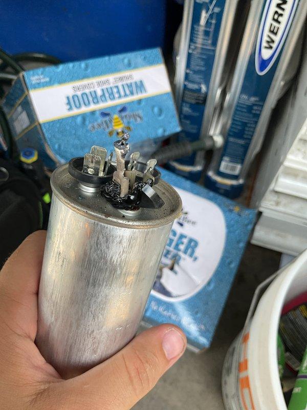 Responded to no cooling call and found outdoor unit running but no airflow from interior vents. Upon inspection, discovered failed dual-run capacitor with visible burn damage and deterioration at terminal connections. Replaced defective JARD 40+5.0µF capacitor with new unit, restored all electrical connections, and verified system operation. Unit now cooling properly with normal airflow restored to all vents.