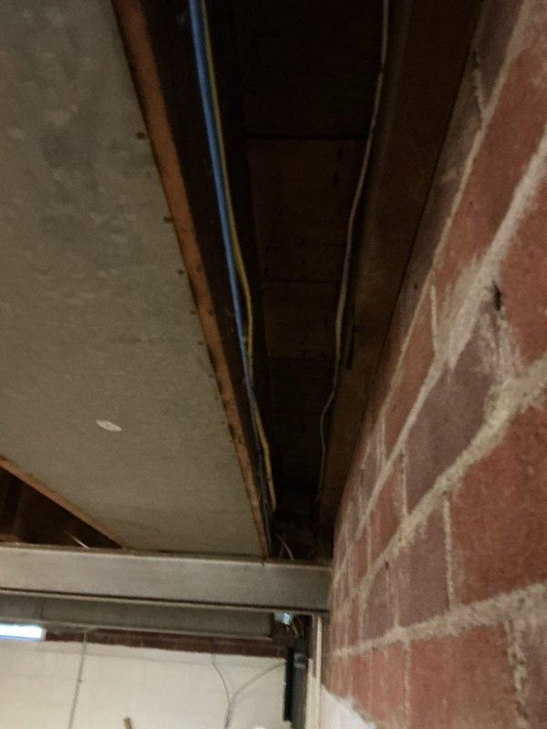 Completed inspector-required corrections including securing exposed electrical wiring with proper stapling, installing draft stop at return air penetration, labeling electrical circuit at panel, and installing code-compliant service receptacle. All items verified and brought into compliance with local building code requirements.