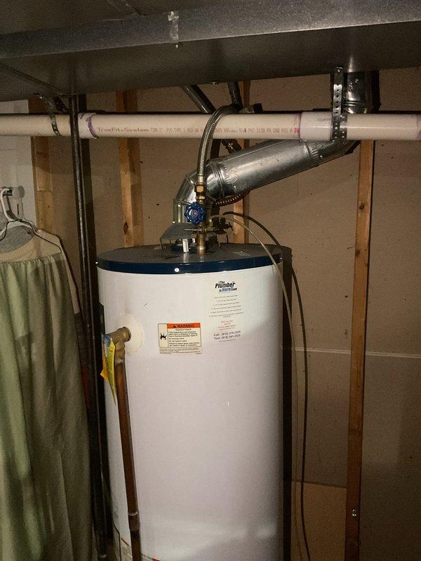 Responded to no hot water complaint on residential gas water heater. Upon arrival, inspected 33-gallon natural gas water heater manufactured by Liberat Master Water Heater Company. Unit serial number 6305582 indicated installation date from 2002, making the water heater approximately 23 years old and well beyond its expected service life. Verified no hot water production and confirmed pilot light would not remain lit after customer's previous relight attempts. Conducted visual inspection of unit and surrounding plumbing connections, confirming no active leaks or water damage present. Examined gas supply, thermocouple, pilot assembly, and burner components. Due to the age of the unit and failure of pilot to remain lit, advised that water heater has reached end of useful life and requires replacement. Documented existing installation configuration including copper supply lines, PVC venting system, and blue shutoff valve at top of tank. Photographed unit specifications and overall install