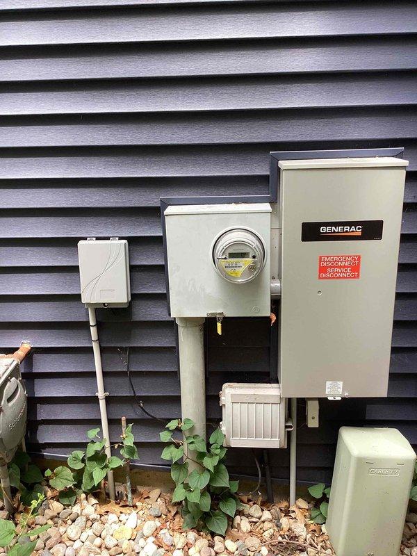 Conducted site assessment for standby generator installation at residential property. Existing Generac transfer switch and electrical wiring already in place and operational. Documented current electrical service configuration including Centron digital utility meter rated at CL200, 240V, 3-wire with 30TA capacity. Verified transfer switch mounting location on exterior wall with adequate clearance and accessibility. Photographed existing infrastructure to prepare Kohler generator equipment proposal. Installation will require generator pad placement, gas line connection, and integration with pre-existing transfer switch system.