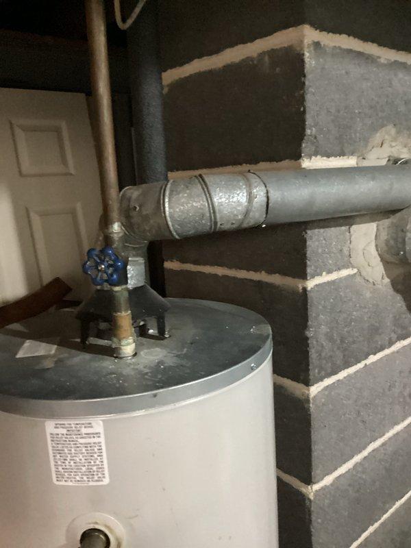 # Water Heater No Hot Water Service Call

Responded to service call for 10-year-old water heater not producing hot water. Upon arrival, performed visual inspection of unit and surrounding plumbing connections in basement utility area. Observed water heater with proper plumbing connections including cold water inlet with blue shutoff valve, hot water outlet piping, and temperature/pressure relief valve discharge line.

Conducted diagnostic assessment of water heater system. Checked electrical connections and power supply to unit. Inspected condition of heating elements and thermostat controls. Verified proper operation of circuit breaker and reset if necessary. Tested water heater functionality after completing diagnostic procedures.

Noted presence of condensation on nearby ductwork, indicating proper humidity levels in mechanical room but no direct impact on water heater operation. All plumbing connections appeared secure with no visible leaks at inlet/outlet connections or relief val