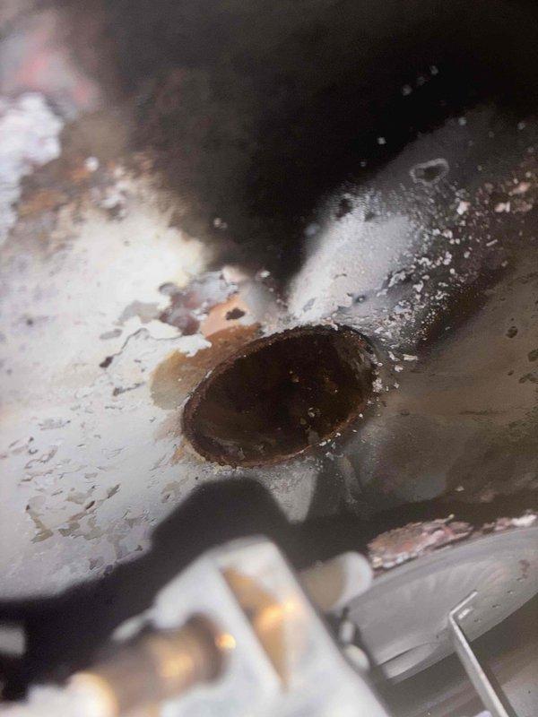 Responded to service call for water heater with pilot light failure and no heating. Upon inspection, discovered extensive rust and corrosion throughout the combustion chamber and burner assembly, indicating prolonged moisture exposure and severe deterioration of internal components. The corroded conditions prevented safe pilot ignition and operation. Documented the failed components with photos showing compromised metal surfaces, rust buildup around burner ports, and deteriorated housing that would require complete unit replacement to restore safe hot water service.