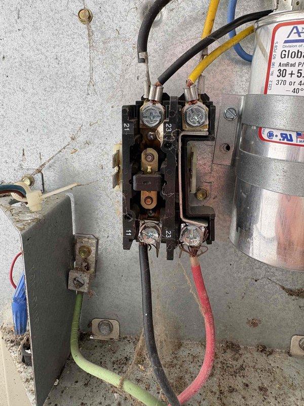 Responded to no cooling call with complete system failure reported. Upon inspection, found failed contactor with severely corroded and oxidized terminal connections preventing proper operation. Contactor showed significant wear with darkened metal components and deteriorated contact points. Replaced defective contactor and inspected dual-run capacitor rated at 30+5 MFD, which tested within acceptable range. Cleaned all electrical connections, secured wiring terminals, and verified proper voltage at disconnect. Cycled system through complete operational test, confirmed compressor engagement, and verified normal amperage draw. System restored to full cooling operation with no further issues detected.
