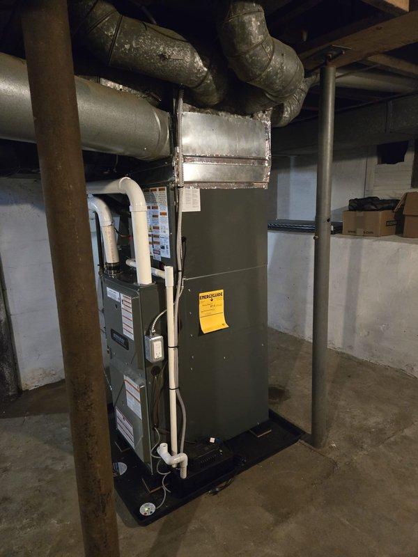 Complete furnace and air conditioning system installation performed in residential property. New furnace unit installed in basement mechanical room on proper platform with associated ductwork connections to existing distribution system. Outdoor condensing unit positioned on ground-level pad with refrigerant line set connections completed using brass fittings and copper tubing. All electrical connections, condensate drainage, and ventilation requirements completed per manufacturer specifications and local code requirements. System tested and verified operational upon completion.