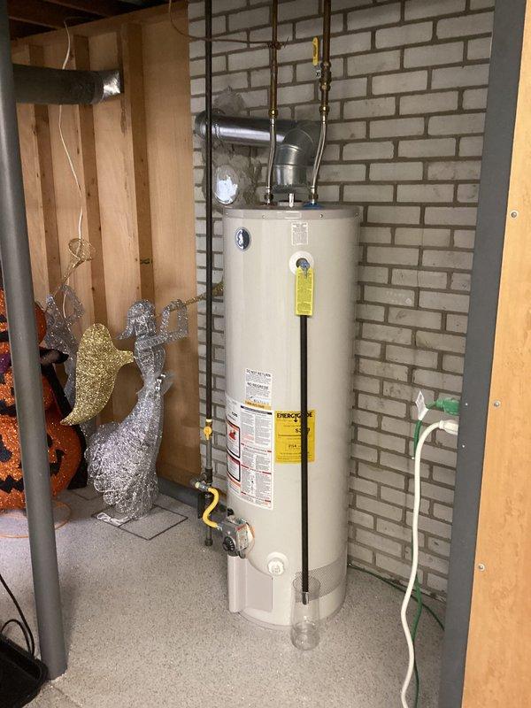 Responded to service call for sump pump backup with black sludge discharge from unit over 8 years old. Upon inspection, assessed existing sump pump system with PVC discharge piping and floor-mounted basin installation. Documented equipment condition and basement utility area configuration, noting pump age and operational failure requiring attention.