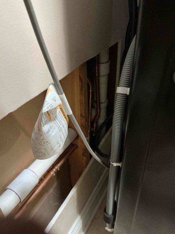 Completed comprehensive plumbing project involving installation of new iron curtain water treatment system with associated PVC and copper supply lines routed through wall cavity. Performed rough-in plumbing for laundry tray installation in utility room, including proper drainage and supply connections within cabinet area. Removed existing Gordon brand iron curtain system and replaced malfunctioning pressure vacuum breaker on irrigation sprinkler system to restore proper backflow prevention. All installations completed to code with appropriate pipe labeling and secure mounting within framing structure.