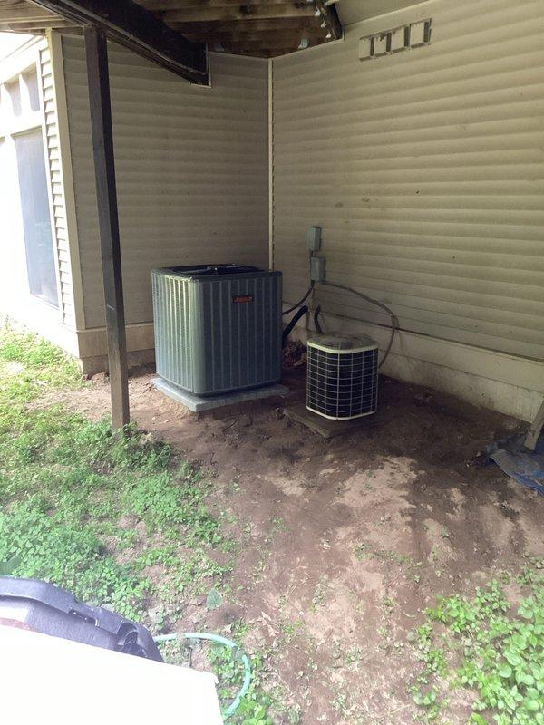 Completed full air conditioning system replacement at residential property. Removed existing aged cylindrical condenser unit and installed new Trane condensing unit in outdoor carport area against exterior wall. Replaced indoor air handler unit in basement mechanical room with new equipment. Installed new refrigerant line set with proper insulation, ran electrical conduit and wiring to both indoor and outdoor components, and connected PVC condensate drainage lines with appropriate fittings and supports. Verified all connections, tested system operation, and confirmed proper airflow through existing ductwork.