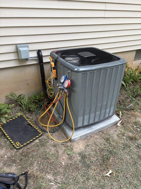 Completed add-on air conditioning system installation at residential property. Installed new outdoor condensing unit on concrete pad with proper electrical disconnect box mounted to exterior siding. Connected refrigerant lines using manifold gauges for system charging and testing. Verified factory charge of 65 oz and added 9 oz field charge per manufacturer specifications for total system charge of 65 oz. Installed flexible ductwork connections to integrate new AC system with existing infrastructure. Performed system startup, pressure testing, and operational verification to ensure proper cooling performance and refrigerant flow. All components functioning within normal operating parameters upon completion.