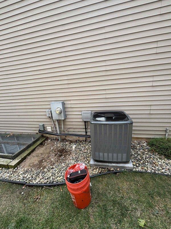 Successfully completed full air conditioning system replacement at residential property. Removed existing AC condenser unit and installed new outdoor condensing unit on concrete pad with proper gravel base for drainage and stability. Unit positioned adjacent to existing electrical meter and service panel for optimal power connection. Verified all refrigerant lines properly connected and sealed, then performed system charging and pressure testing using calibration manifold gauges to ensure proper refrigerant levels and system operation within manufacturer specifications. Confirmed low-side and high-side pressures within acceptable ranges for optimal cooling performance. System tested and operational upon completion.