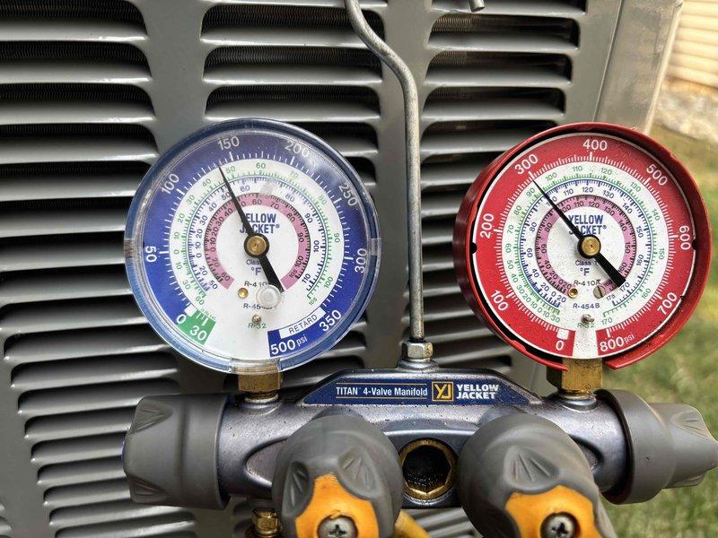 Successfully completed full air conditioning system replacement at residential property. Removed existing AC condenser unit and installed new outdoor condensing unit on concrete pad with proper gravel base for drainage and stability. Unit positioned adjacent to existing electrical meter and service panel for optimal power connection. Verified all refrigerant lines properly connected and sealed, then performed system charging and pressure testing using calibration manifold gauges to ensure proper refrigerant levels and system operation within manufacturer specifications. Confirmed low-side and high-side pressures within acceptable ranges for optimal cooling performance. System tested and operational upon completion.