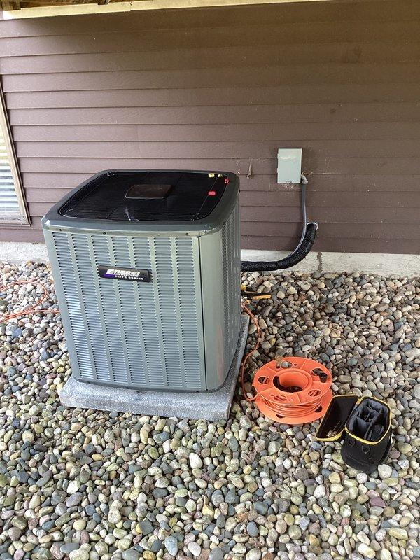 Completed full air conditioning system replacement at residential property. Removed existing outdoor condensing unit and installed new replacement unit on existing concrete pad with proper refrigerant line connections, electrical hookup via wall-mounted junction box, and condensate drainage. Verified all safety labels and manufacturer specifications are visible and compliant. System tested and confirmed operational upon completion.