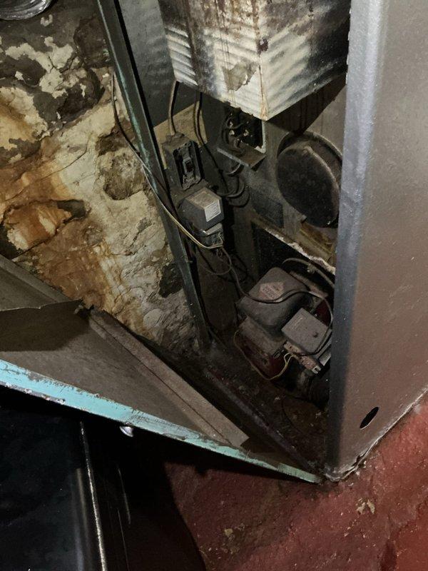 Responded to no cooling complaint at single-family residence with 25-30 year old air conditioning system. Upon arrival, confirmed compressor failure with complete loss of cooling throughout home. Inspected outdoor condensing unit and indoor components located in basement utility area. Found compressor motor inoperable with no electrical draw, indicating internal mechanical failure consistent with age of equipment. Evaluated electrical connections, capacitor, and contactor operation; confirmed power supply reaching unit but compressor not engaging. Given the advanced age of the system and extent of component deterioration observed in basement installation area, recommended full system replacement rather than compressor repair due to cost-effectiveness and reliability concerns. Documented equipment condition with photographs showing basement mechanical room layout and aged ductwork with visible corrosion. Provided customer with replacement options and explained benefits of upgrading to m