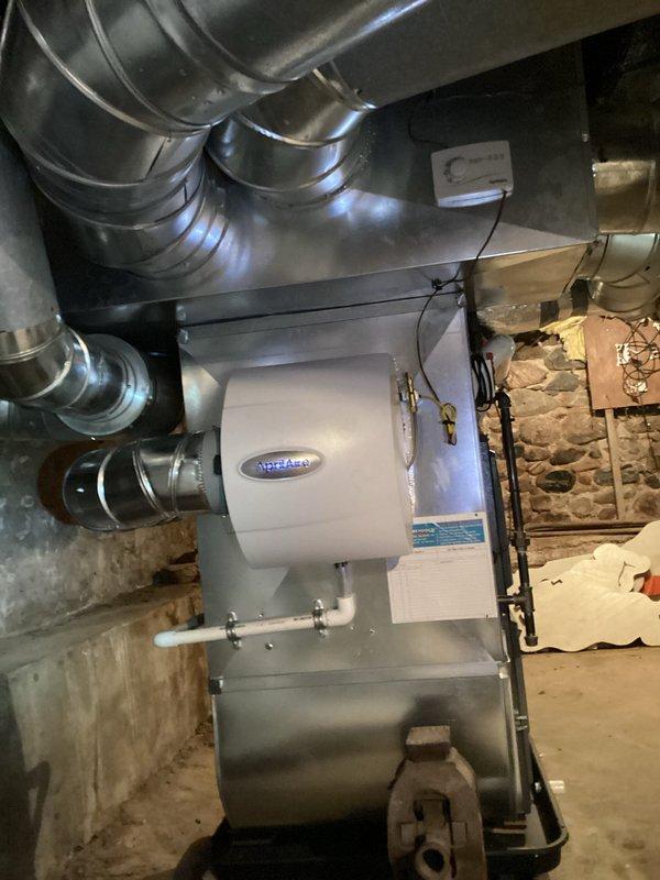 Completed installation of AprilAire whole-home humidifier with manual control in basement mechanical room. Unit was mounted to existing HVAC ductwork system and connected to metallic supply ducts, with all electrical connections terminated and water supply line plumbed to humidifier. System tested and verified operational upon completion.
