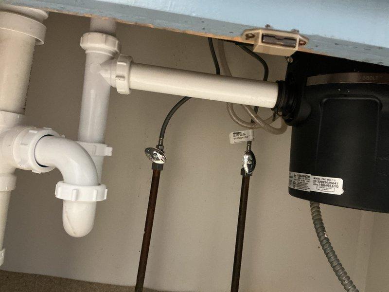 Installed new Insinkerator garbage disposal unit under kitchen sink in 1957-era home. Completed installation includes proper electrical connection via armored cable, PVC drain plumbing with P-trap assembly, and secure mounting to underside of countertop. Verified unit operates correctly with existing double-basin stainless steel sink and drain configuration. All connections tested and confirmed leak-free.